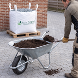 Kruiwagen met tuingrond wordt gevuld vanuit de bigbag
