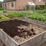 Groencompost doorgespit in een moestuinbed met spitvork