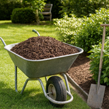 Kruiwagen gevuld met epicea boomschors 20-40 mm in de tuin