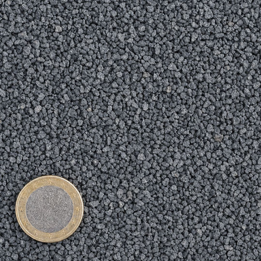 Kalksteenslag 2/4 mm van bovenaf, op schaal naast een munt van 1 euro (gezichtsveld 9 bij 9 cm)
