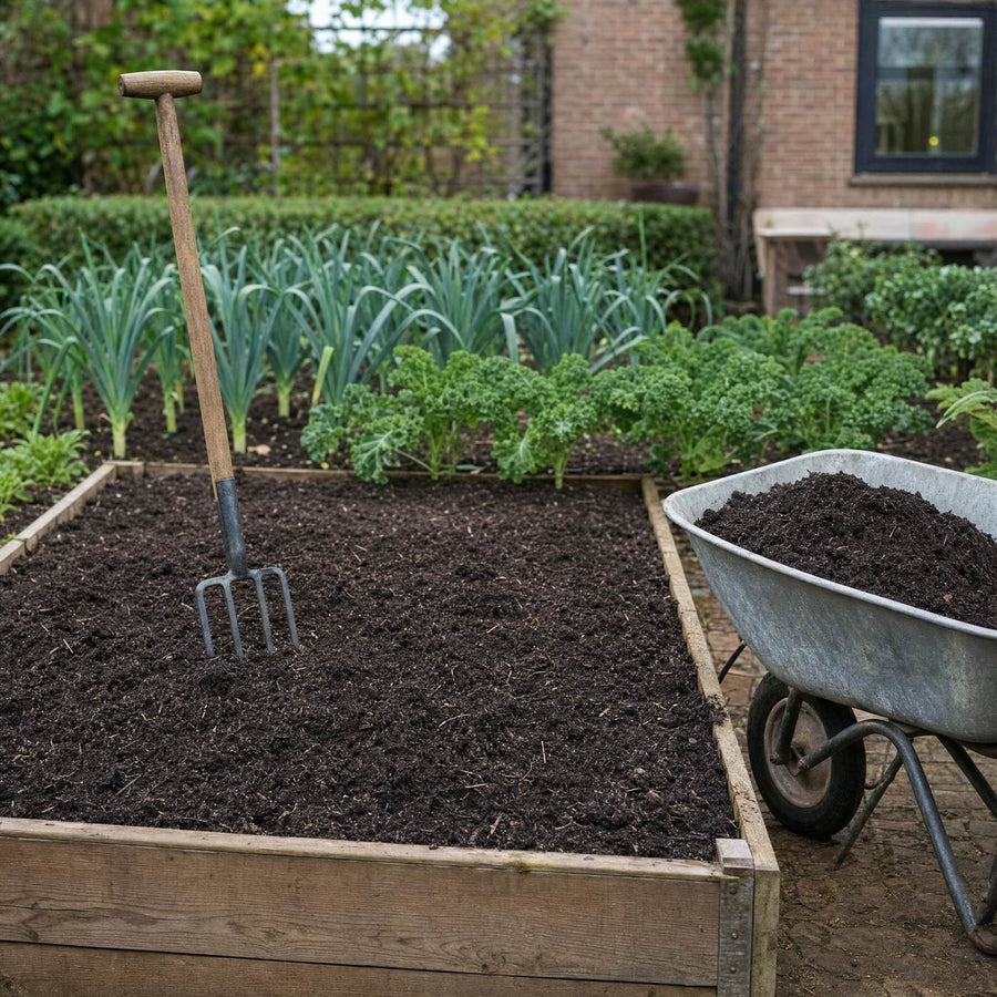Verhoogd moestuinbed met mengcompost, spitvork en kruiwagen